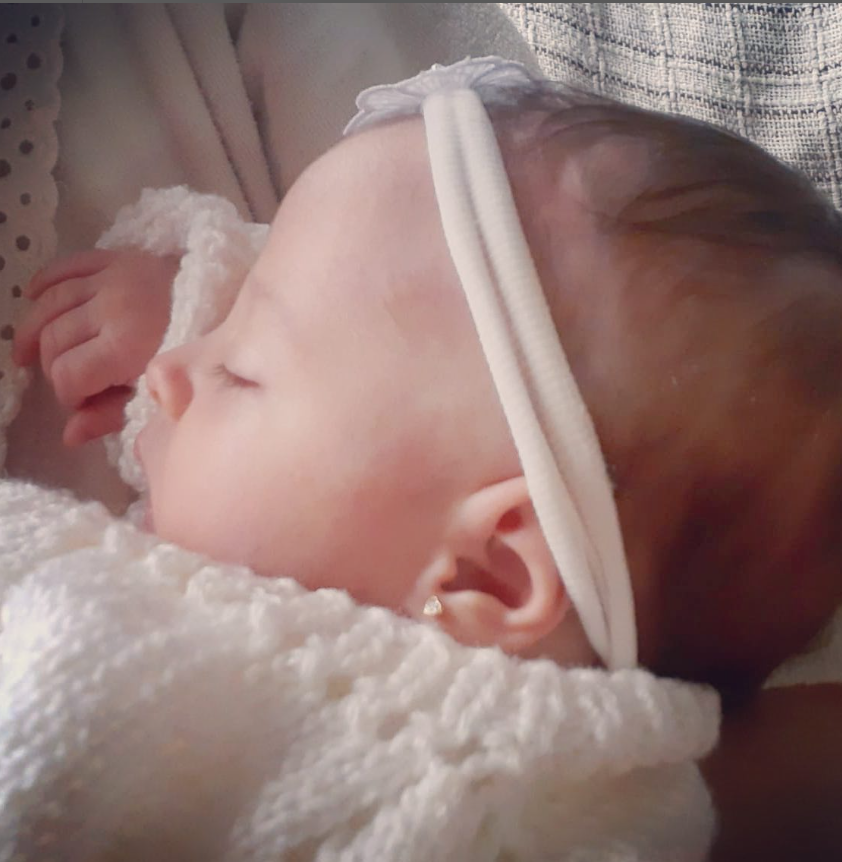 Bebê dormindo com brinco
