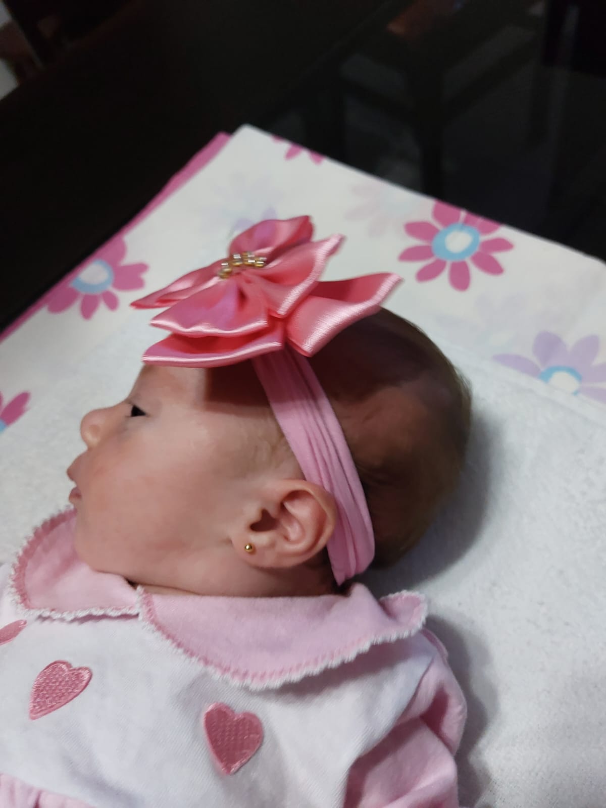 Bebê com brinco e faixa
